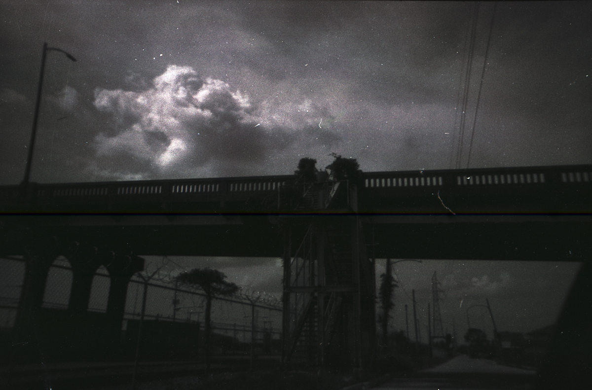 black and white photo of a street by a train track