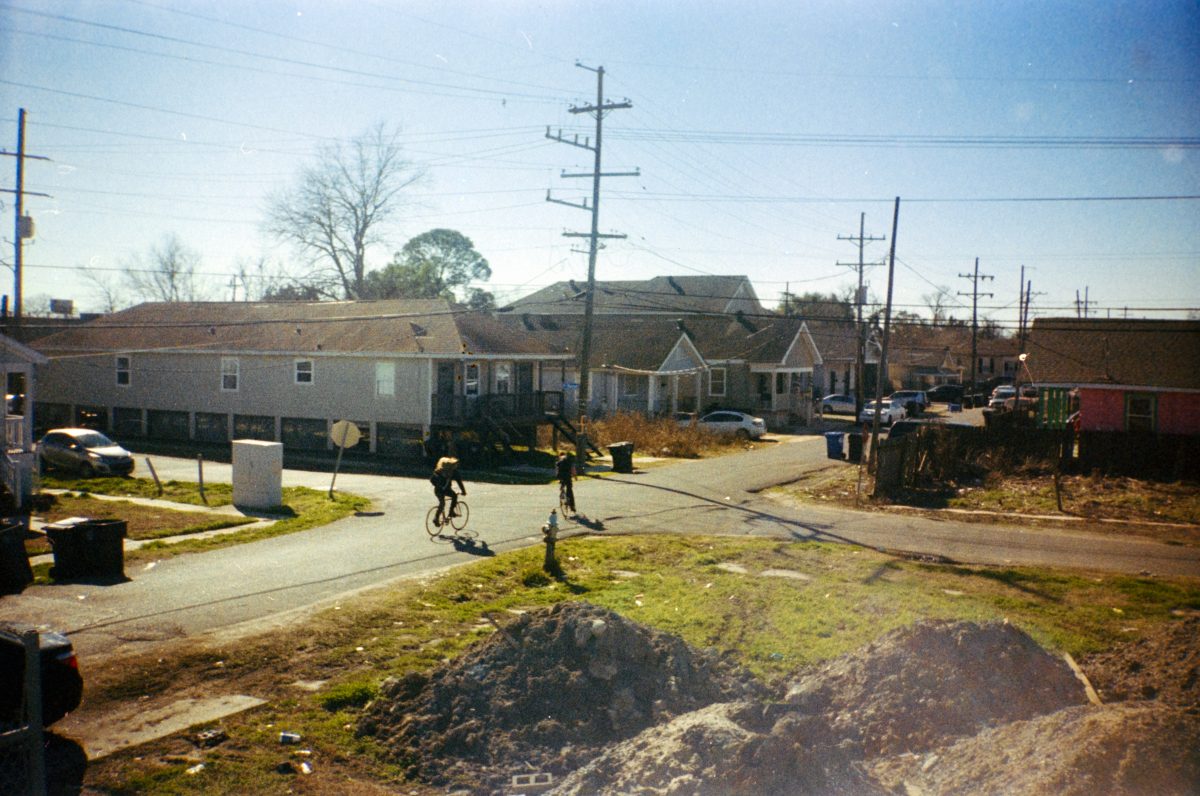 two people with large packs biking in new orleans ninth ward