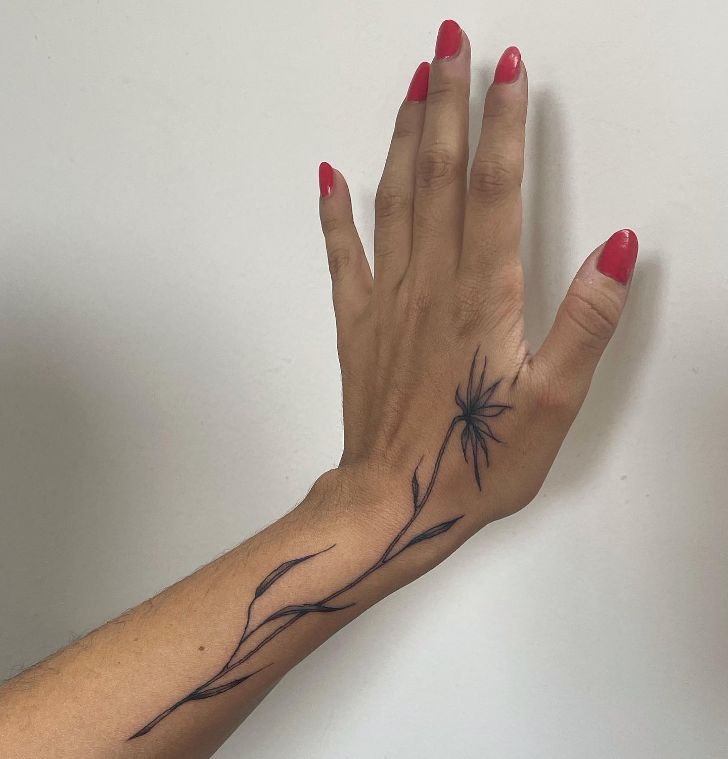 tattoo of a flower on hand and wrist