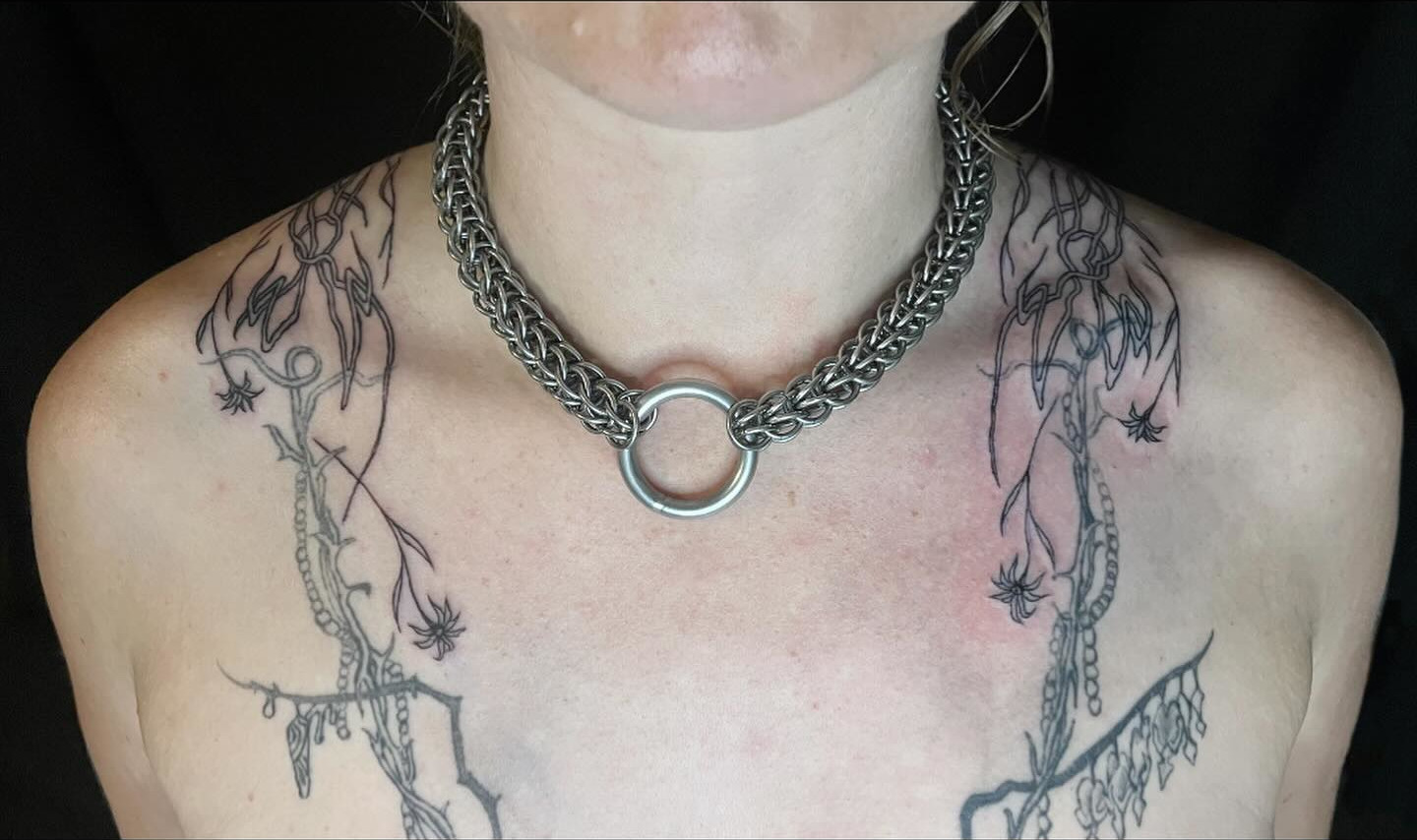 tattoo of a chain harness around neck