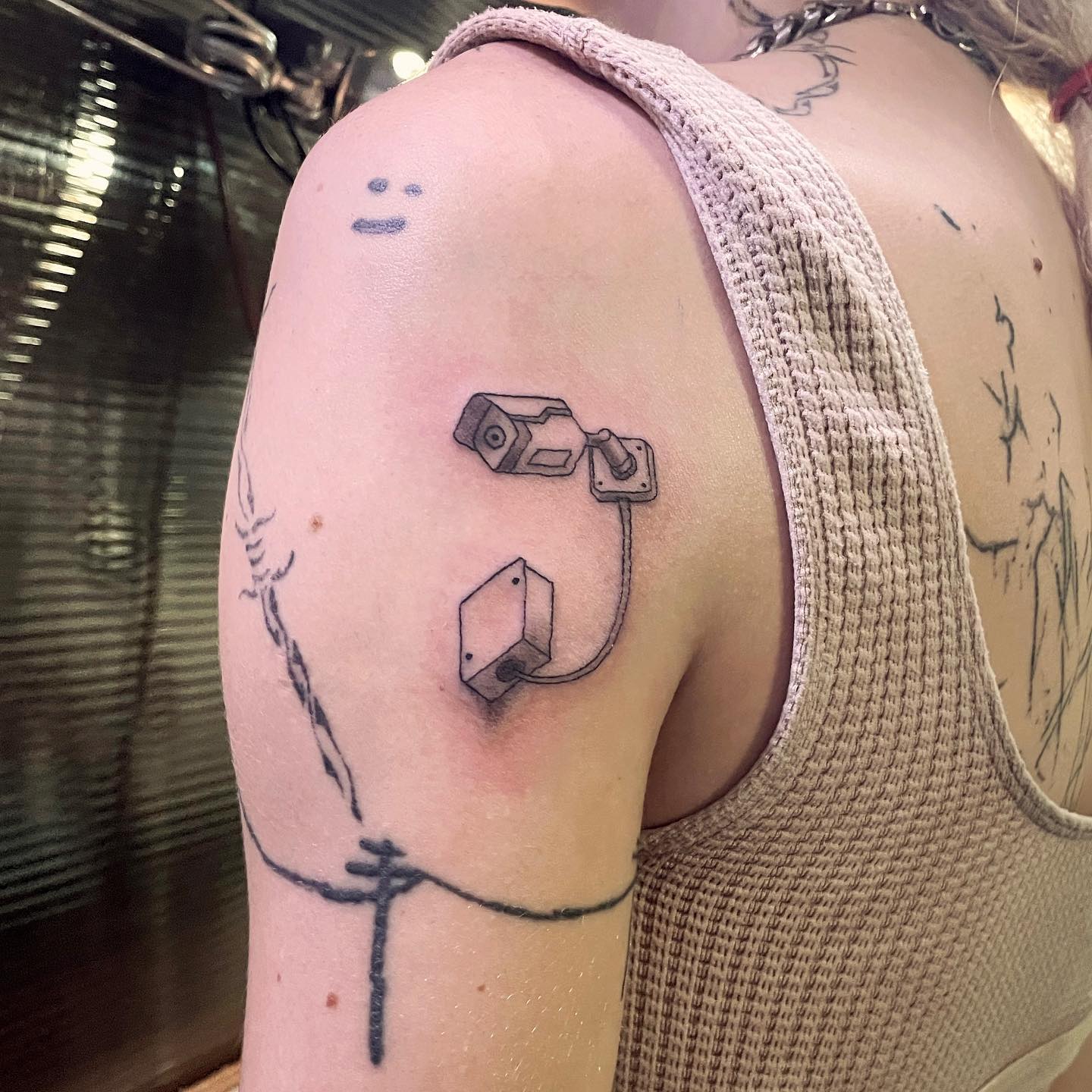 tattoo of a small security camera on arm