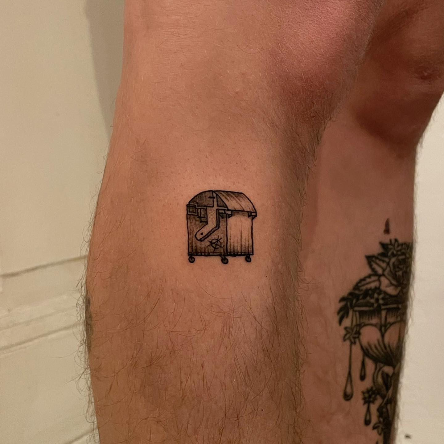 tattoo of a small dumpster on leg