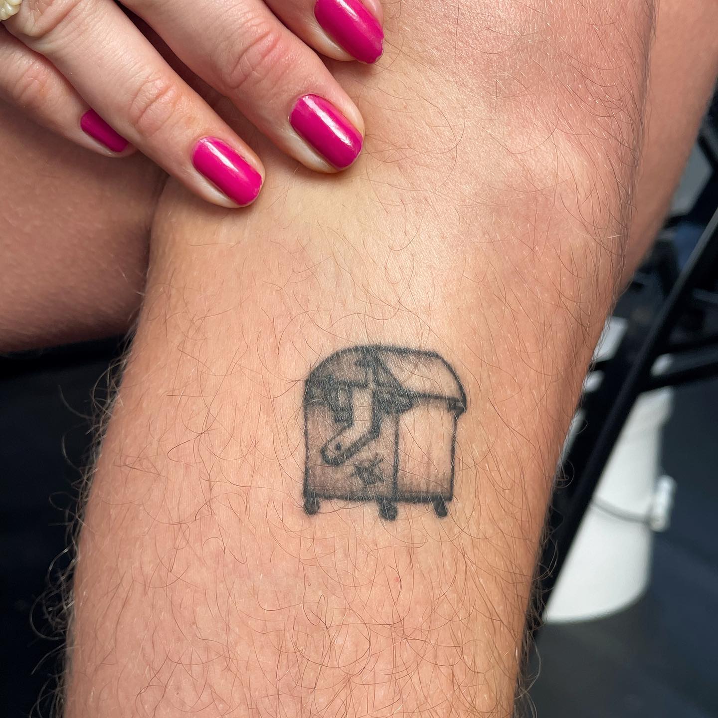 tattoo of a small dumpster on leg, healed