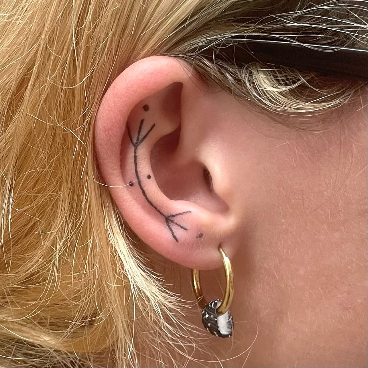 tattoo of a small design on inside of ear