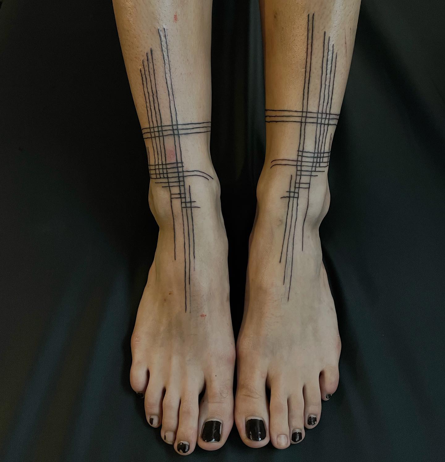 tattoo of matching gridlike anklets on leg