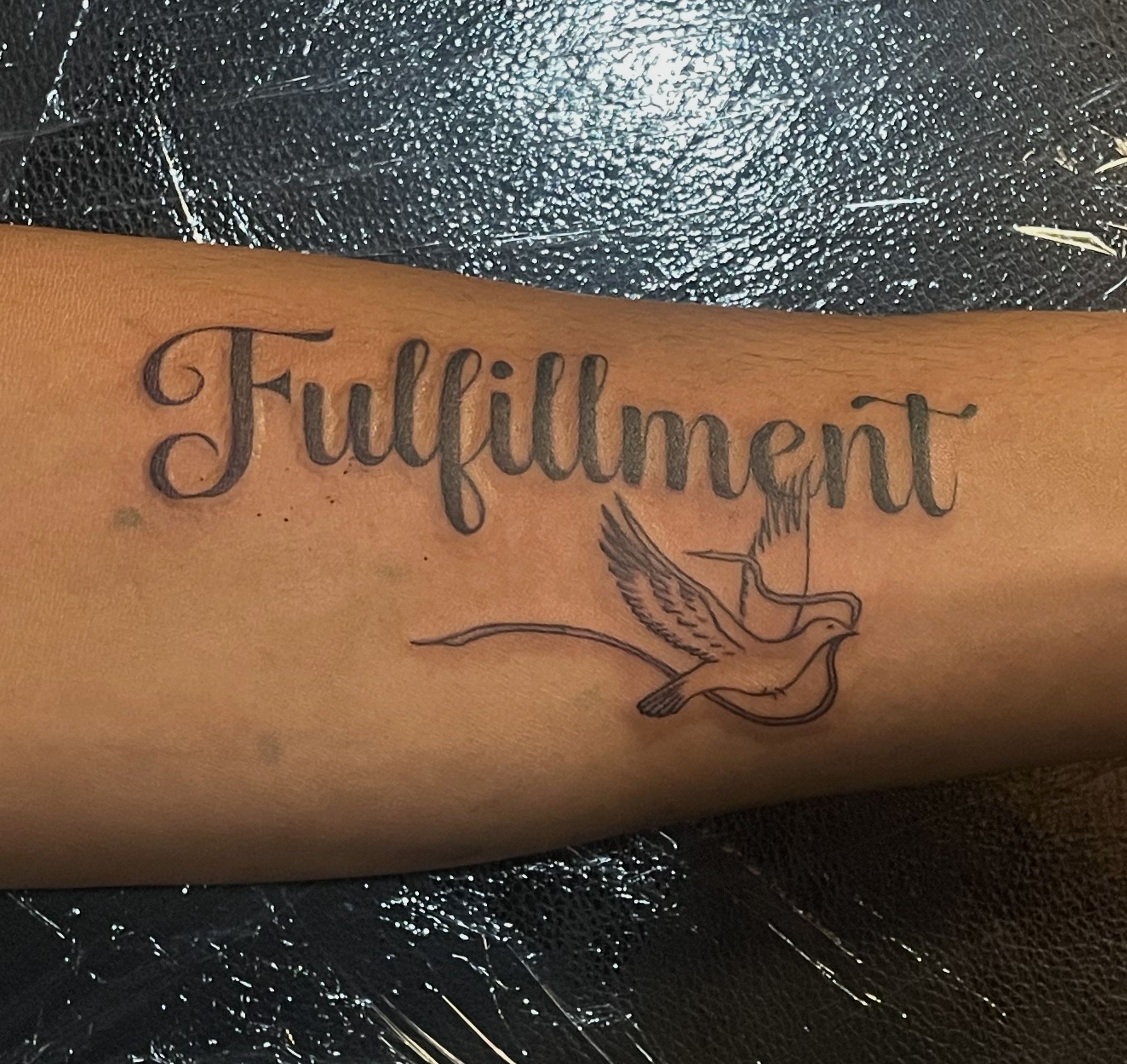 tattoo of words that say fulfillment on an arm
