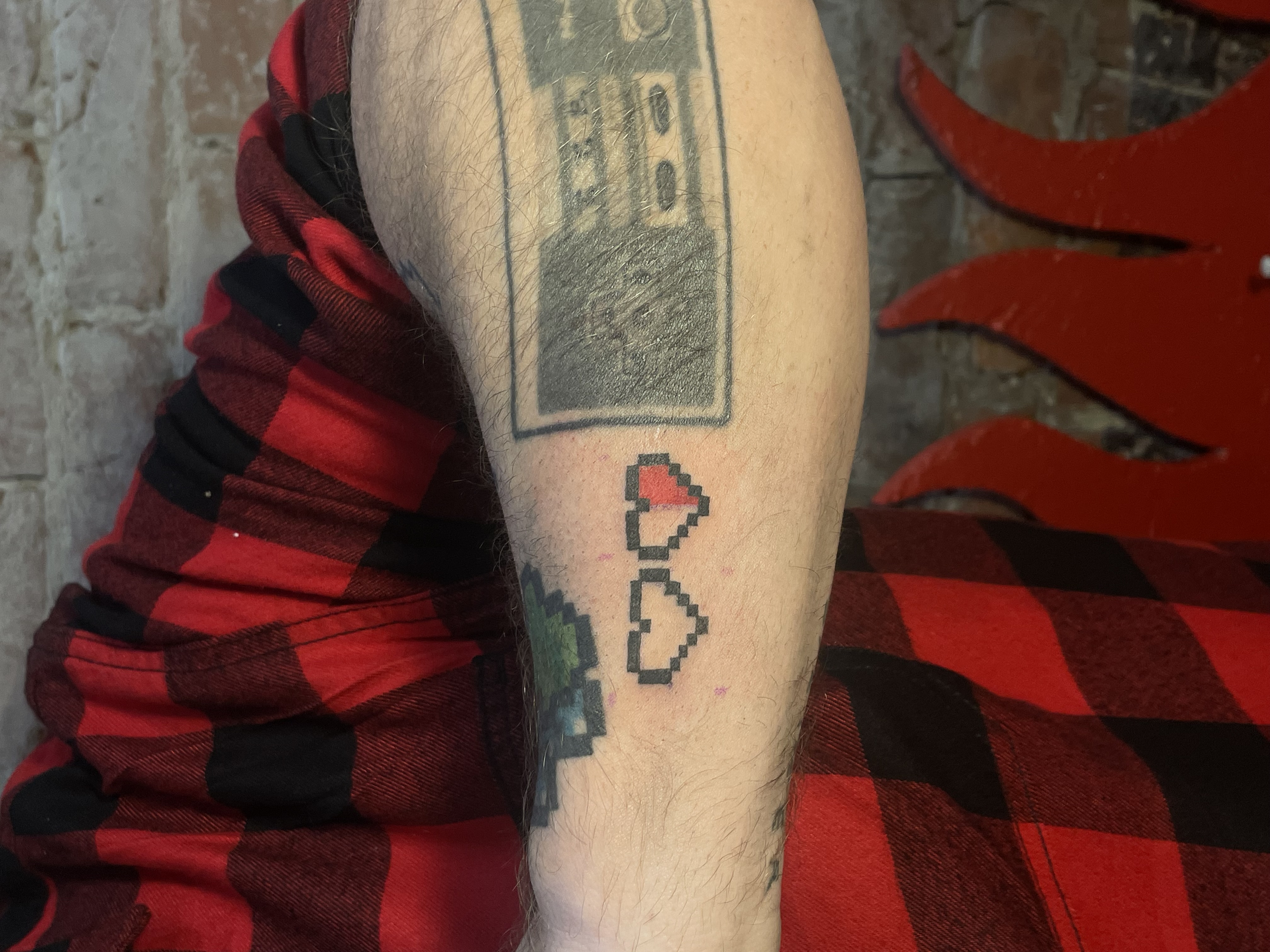 tattoo of pixel hearts on an arm