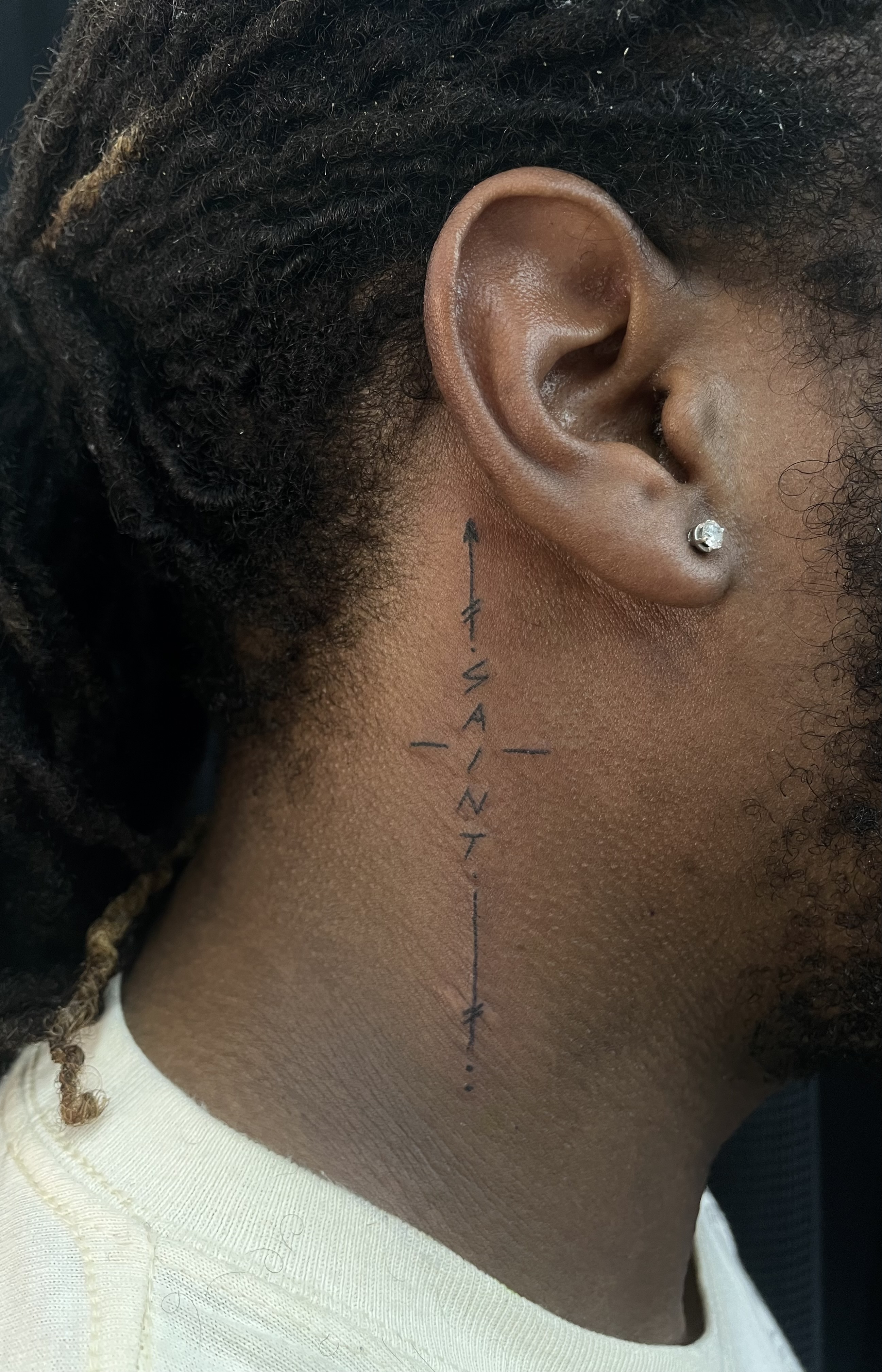 tattoo of the word saint on a neck