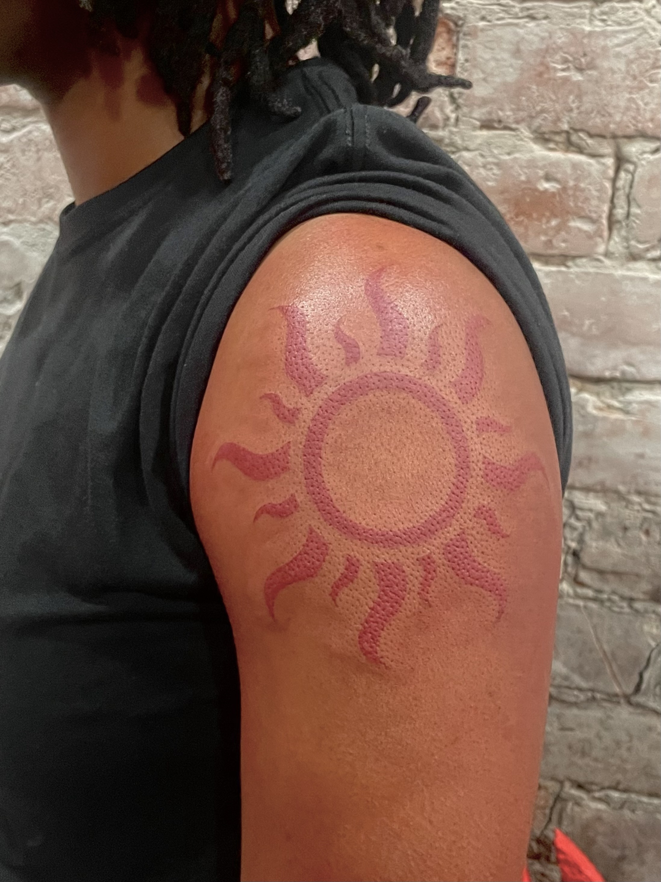 tattoo of a big tribal sun on an arm